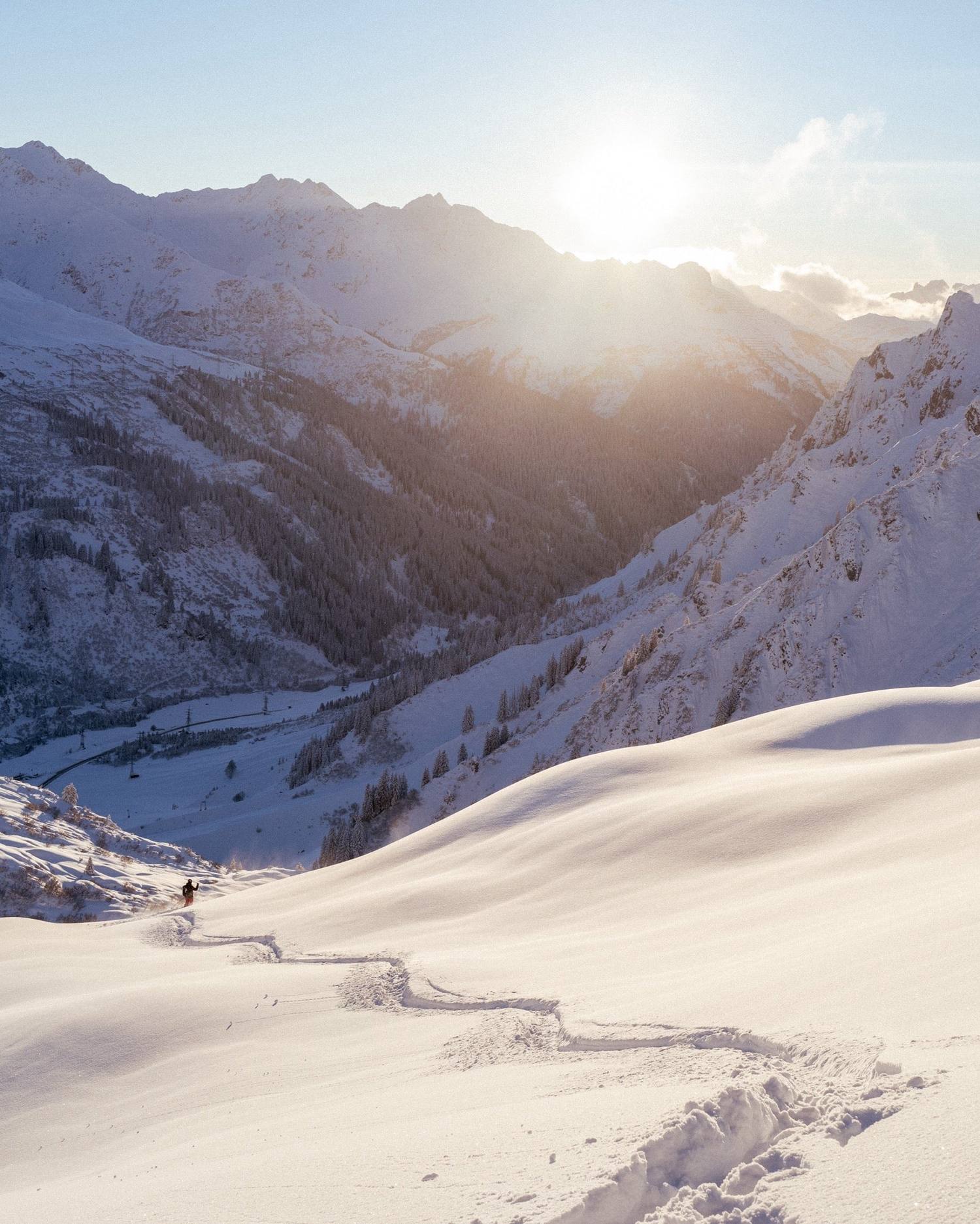 A single skier traversing the wide Flexenmulde bowl above Zürs